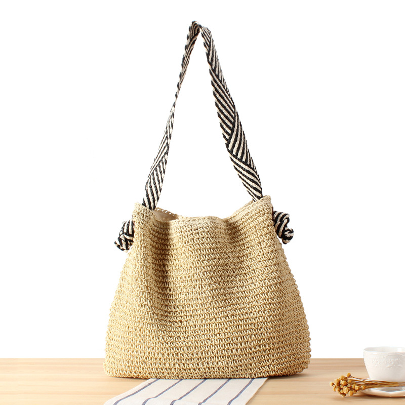 Handgevlochten rattan strandtas in boho stijl met naturel vlechtwerk en schouderband voor de zomer